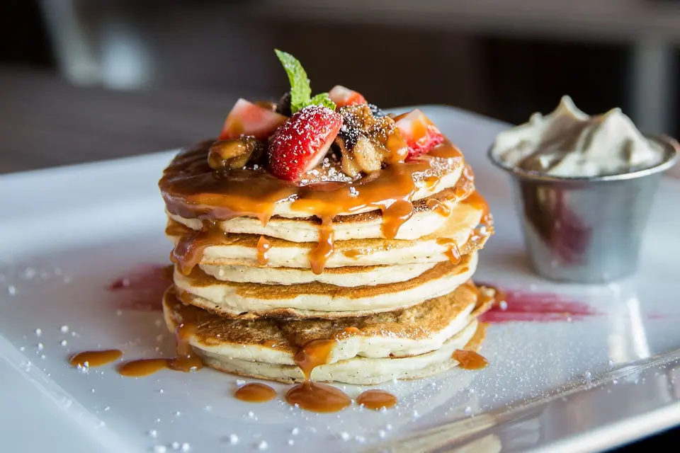 Pile de pancakes avec fraises, myrtilles et sirop