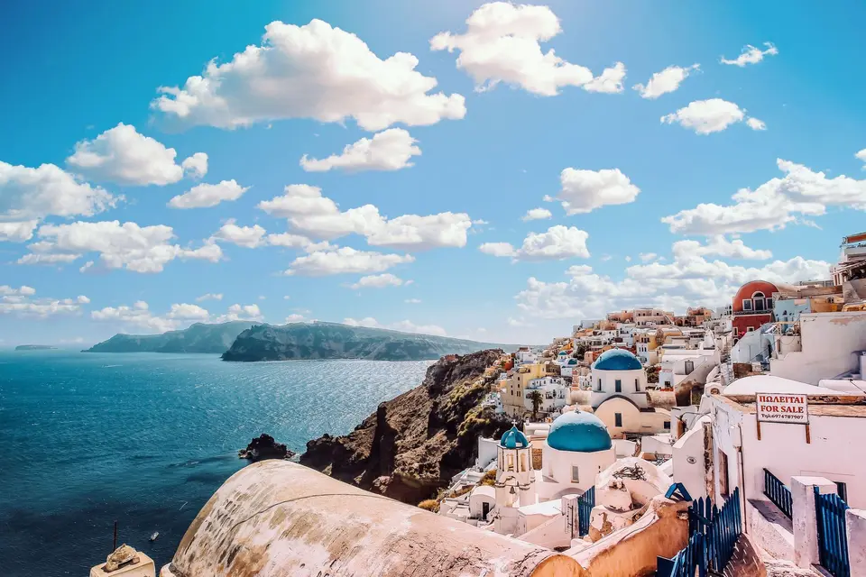 Bâtiments blancs et coupoles bleues au-dessus de la mer à Santorin
